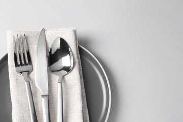 Wall Mural - Stylish silver cutlery, plate and napkin on white background, top view. Space for text