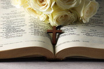 Wall Mural - Bible, cross and roses on light table, closeup. Religion of Christianity