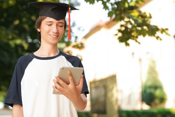 Canvas Print - Male graduating student with tablet computer outdoors