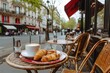 © Supranee - A cozy outdoor cafe setting featuring a cup of coffee and croissants, perfect for enjoying a leisurely morning in Paris.