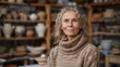 © Johannes - Medium shot portrait photography of a satisfied woman in her 50s that is wearing a cozy sweater against a traditional pottery studio with craftspeople at work background . Generative AI