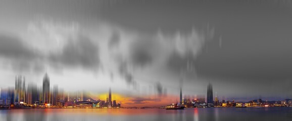 Poster - An evening cityscape in Hong Kong, China with a blurry skyline and a gray sky. The city lights create a colorful glow reflecting on the water.