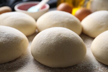 Wall Mural - Raw dough balls with flour on table, closeup