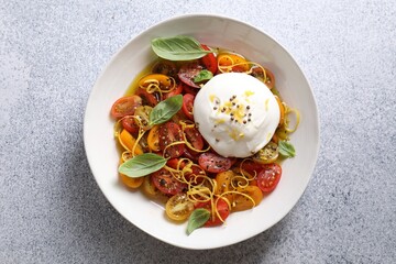 Wall Mural - Delicious fresh burrata salad in bowl on light gray textured table, top view