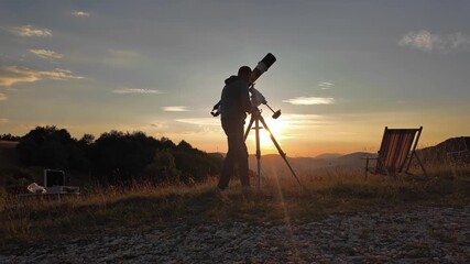 Wall Mural - Amateur astronomer looking at the evening skies, observing planets, stars, Moon and other celestial objects with a telescope just before sun down.	
