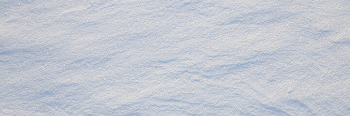 Wall Mural - Beautiful winter background with snowy ground. Natural snow texture. Wind sculpted patterns on snow surface. Wide panoramic texture for background and design.