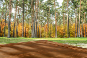 Sticker - Autumn empty brown wooden table top with copy space for products. Blurred autumn forest and opening background.