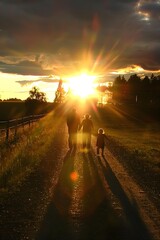 Wall Mural - Family Silhouettes Walking Towards the Setting Sun