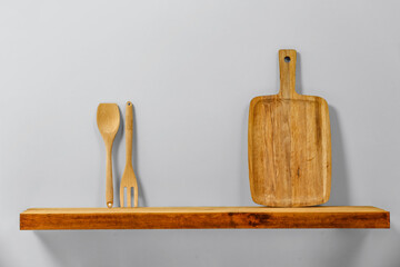 Canvas Print - Wooden kitchen utensils on wooden board with white wall background.