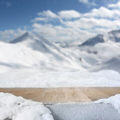 Wall Mural - Wooden table with copy space for products and snow covered mountains winter background