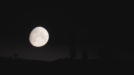 Wall Mural - a full moon shines brightly as it moves in the dark night sky, with a clear view of its surface show
