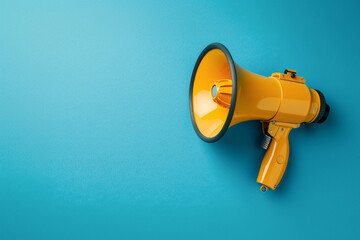 Yellow megaphone isolated on blue background.  Symbol of communication and amplification.