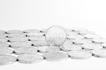 Indonesian five hundred rupiah coin standing with other coins isolated on plain white background. National currency. Indonesian rupiah coin. Copy space.