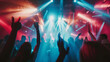 © VK Studio - A crowd enjoys a concert, cheering with hands raised as vibrant red and blue lights flood the scene with energy and excitement.