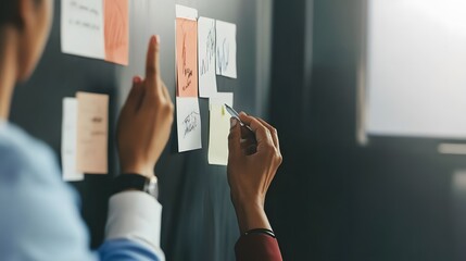 Sticker - A woman writes on a sticky note while collaborating with a colleague.