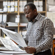 © EeLco - South-African man inspector in office looking at blueprints