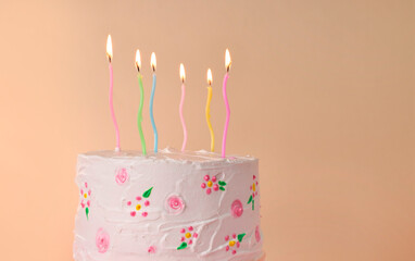 Wall Mural - Tasty Birthday cake with burning candles against beige background. Space for text