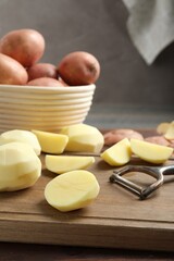 Wall Mural - Fresh raw potatoes and peeler on table