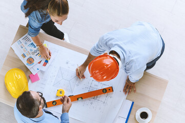 Top view of engineers team meeting for architectural project. architects discussing blueprint with construction manager in office worker conference site. Construction Concept.