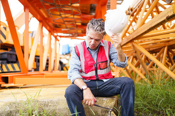 Construction worker is resting and sitting on the floor.