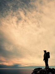 Sky, mountain peak or silhouette of man hiking at sunset in outdoor adventure in nature for travel or break. Space, view mockup and hiker on hill for holiday vacation, exercise or trekking to explore