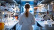 © vanilnilnilla - Back view of a scientist working in a laboratory with blurred lab equipment and samples
