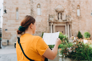 Young beautiful Hispanic 30s woman looking city map at street, old town. Attractive young female tourist is exploring new city. Traveling Europe, High quality photo