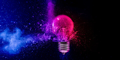 Wall Mural - Pink light bulb exploding in colorful powder on black background