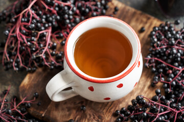 Poster - A white dotted cup of tea with black elderberry syrup