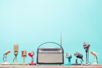 Poster - Retro radio and old microphones for press conference or interview on table front gradient aquamarine background. Vintage old style filtered photo