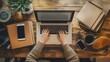 © Stefan - Aerial top view of an office desk businesswoman typing on the keyboard of a laptop brainstorming wooden table with a coffee cup, folders or notebooks mobile phone gadgets internet freelancer job space