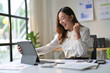 © PaeGAG - Young Professional Woman Celebrating Success While Working on Tablet in Modern Office Environment