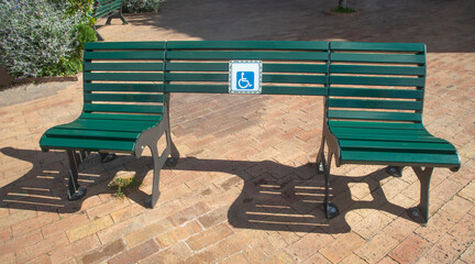 Green park bench with wheelchair space