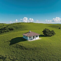 Scenic green landscape featuring cozy white house surrounded by rolling hills and blue sky