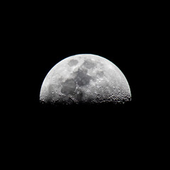 Wall Mural - half moon close up in a black background.