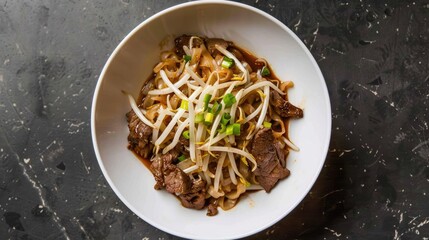 Wall Mural - Top view of a bowl of beef chow fun noodles with green onions and bean sprouts on a white plate.