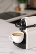 © brizmaker - Espresso maker brewing coffee with milk in a white mug