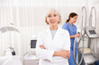 © JackF - Smiling old woman doctor posing against background of cosmetology devices in aesthetic clinic