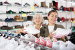 © JackF - Young woman and elderly woman in casual wear choose pair of sneakers in shoe store