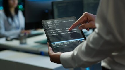 Programmer using device in data center, managing servers, operating systems. Close up of specialist in server hub using tablet to ensure networks are secure and functioning properly, camera A