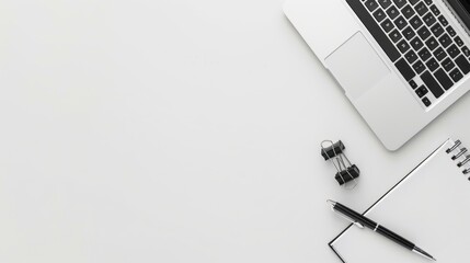 White Desk with Laptop, Notepad, Pen and Binder Clip.