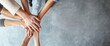 © 为轩 张 - Top view of diverse hands joined together on a light grey background, representing teamwork and collaboration with space for text.