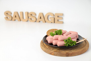 Wall Mural - Small sausages in a bowl with parsley and bread