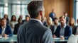 © VistaVisions - Confident businessman giving a presentation in front of crowd in meeting conference seminar room. Leadership authority teamwork in business concept