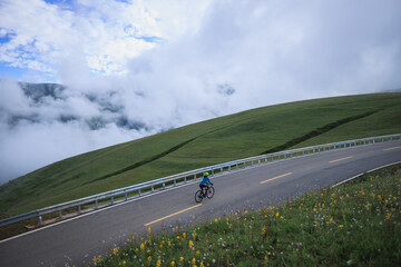 Canvas Print - Riding mountain bike on grassland mountain top