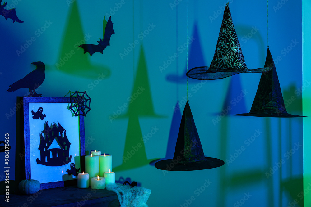 Witch hats hanging in dark room decorated for Halloween