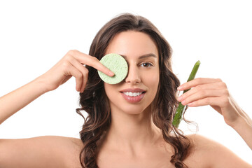 Beautiful young woman with aloe vera covering one eye with cleansing sponge on white background