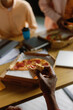© Oleksii Syrotkin/Stocksy - Creative office workers team coffee break. Eating pizza together