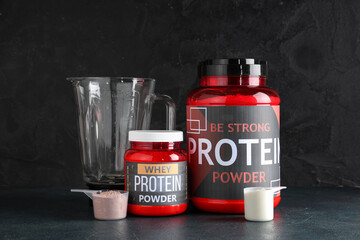 Poster - Bottles with protein powder, scoops and blender on dark background