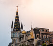 © M.Nergiz - Editorial photo of a uniquely designed building with a tall, pointed spire and gold accents, showcasing eclectic architecture in Batumi, Georgia at sunset.